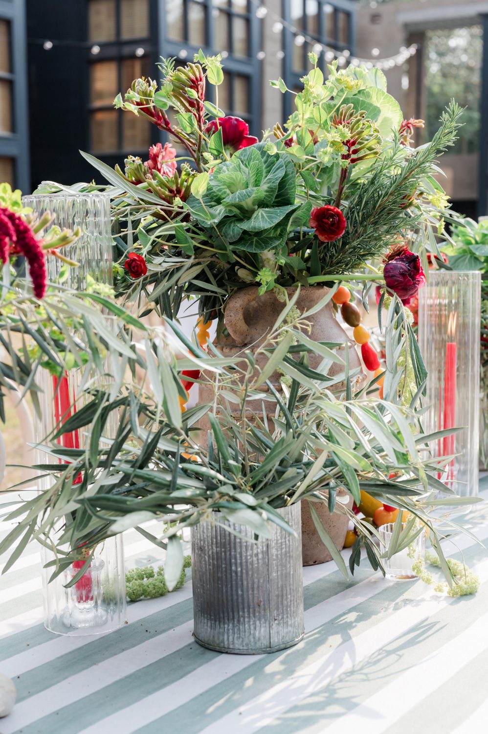 Floral display featuring garden blooms and ripe tomatoes styled for an Italian-themed rehearsal dinner at The Inn at Middleton Place during a multi-day wedding weekend, combining organic textures, seasonal produce, and elegant tablescape design.