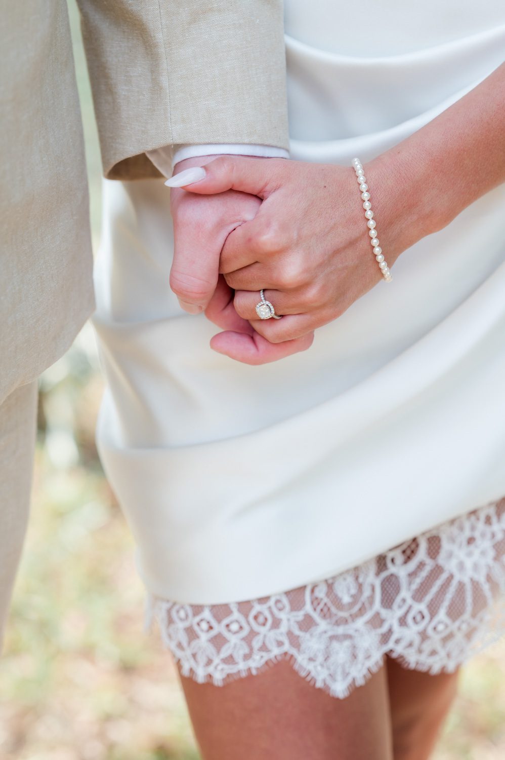 Engaged couple holding hands, walking closely together and sharing a quiet, intimate moment that reflects connection and anticipation for their wedding day.