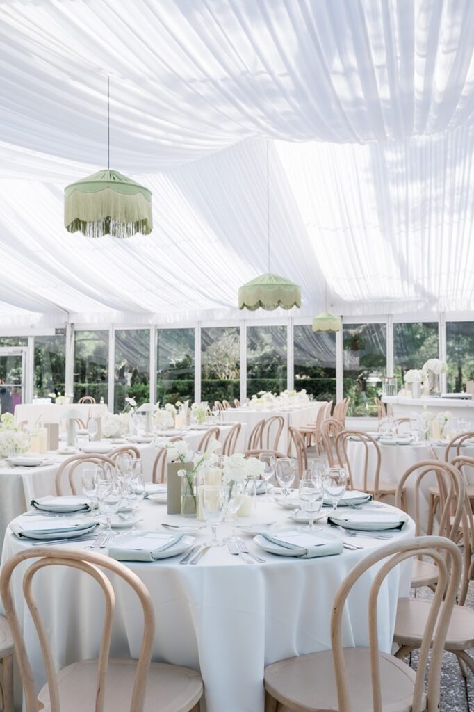 Tented wedding reception with white draping at Lowndes Grove with wooden chairs