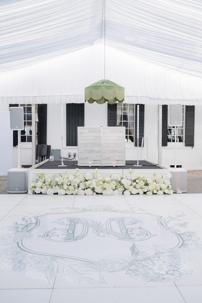 Dance floor with initial monogram o floor with florals and DJ set uo on stage