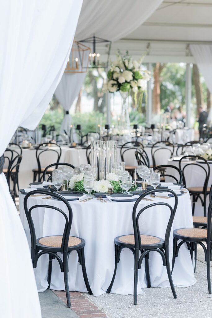 Wedding reception with black chairs, candles, and plates