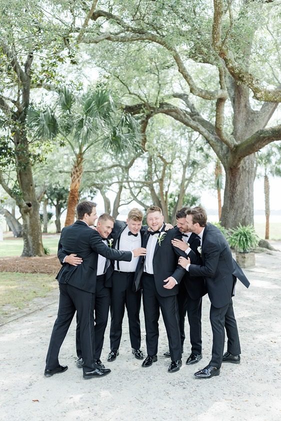 groomsmen at Lowndes Grove cheer on groom under oak trees
