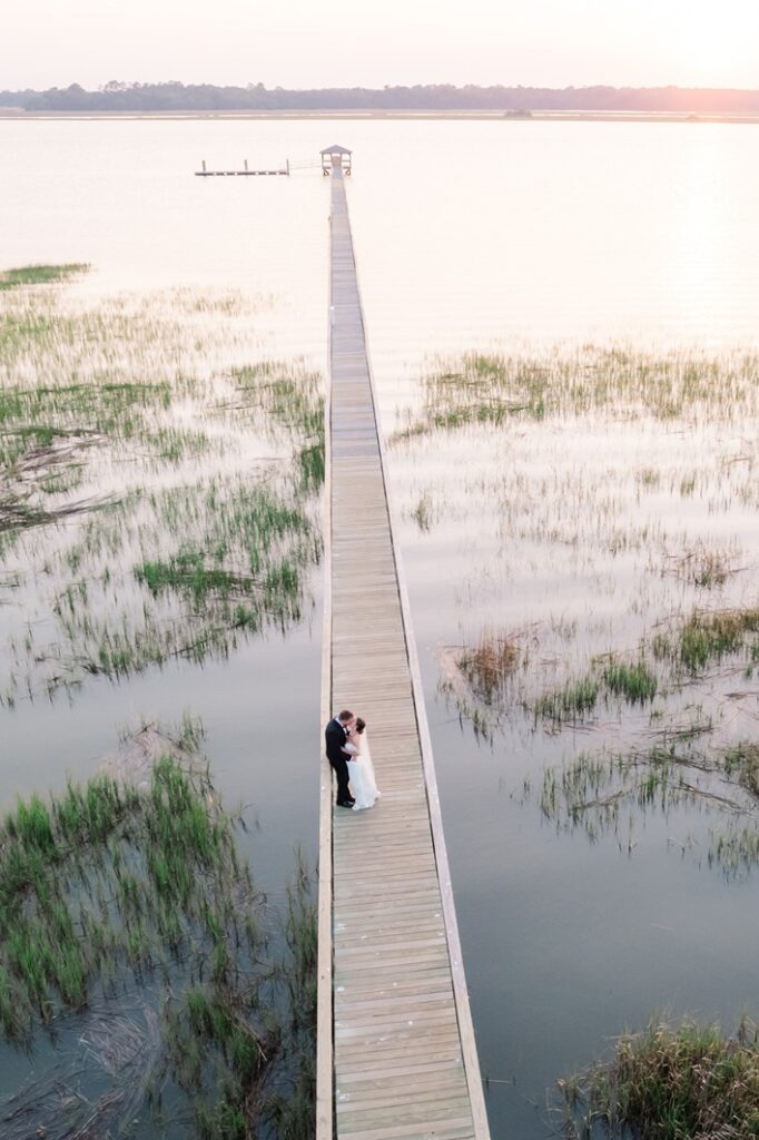 Drone photos of Bride and groom kissing on the dock at Lowndes Grove wedding venue in Charleston SC