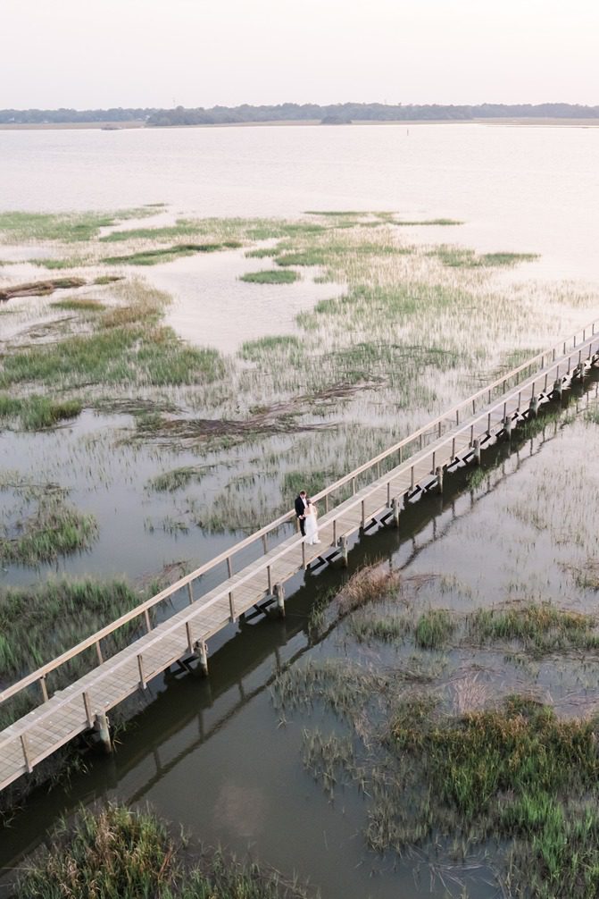 Drone photo of newlyweds at sunset Lowndes Grove dock in Charleston, SC