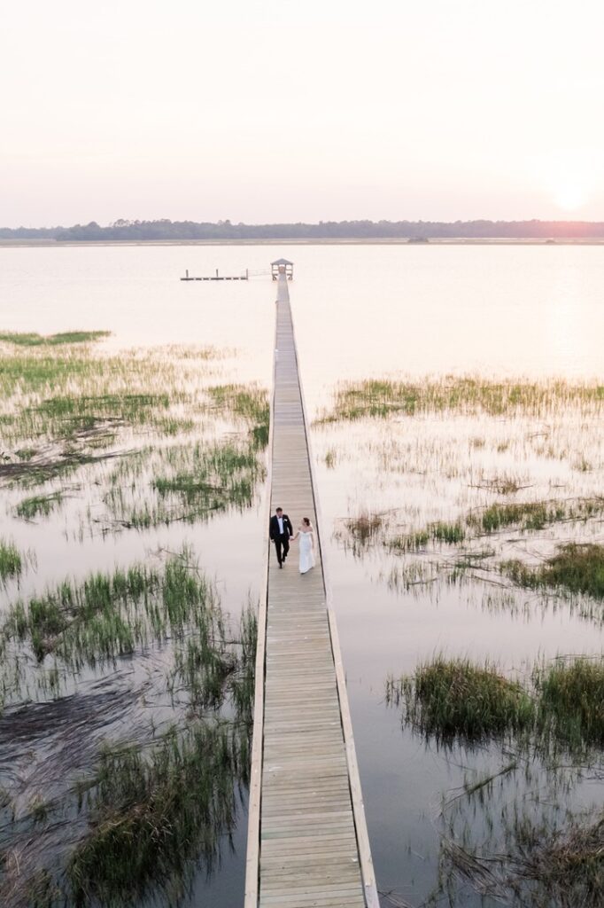 drone photo at sunset overlooking newlyweds walking down the dock at Lowndes Grove